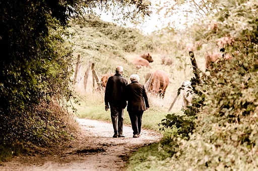 old couple walking in the woods
