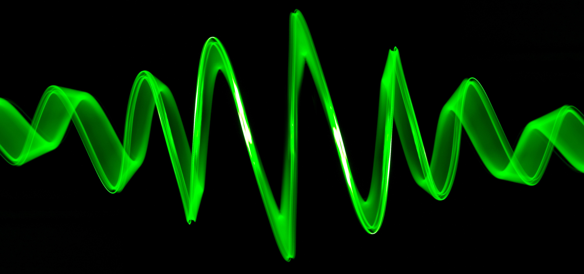 Bright green soundwave against a black background