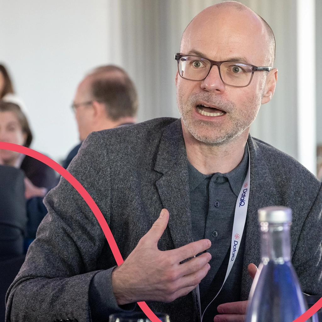 A male data and AI leader passionately discussing data and AI at a DataIQ discussion
