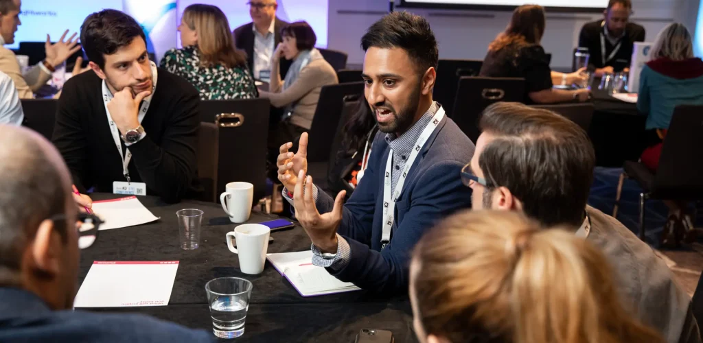 A group of people engaged at a roundtable discussion.