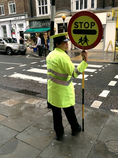 Lollipop lady at a zebra crossing
