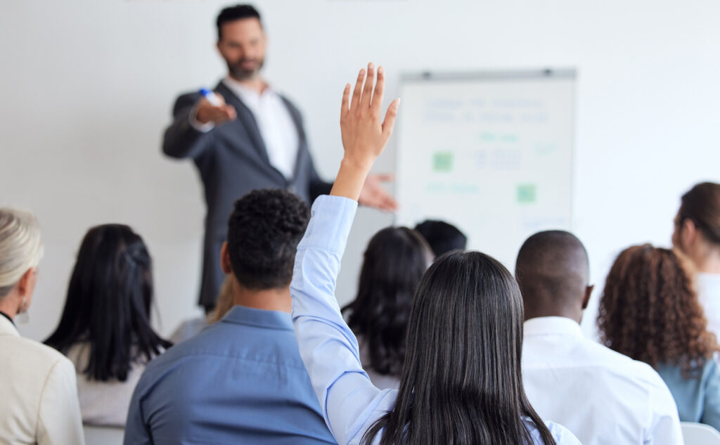 An apprentice raises their hand in a data academy seminar to ask a question.
