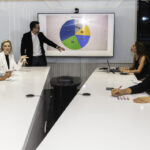 A team of data professionals sit around a desk and examine their data strategy.