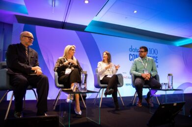 Four CDOs sitting on a panel in front of an audience of data professionals.